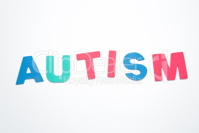 Autism spelled out in pink green and blue