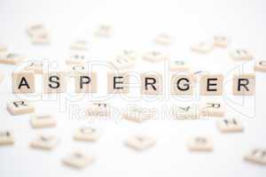 Asperger spelled out in plastic letter pieces with others scatte