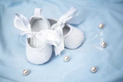 White baby booties on blue blanket