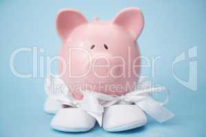 Piggy bank wearing white baby booties