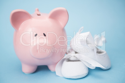 Piggy bank and white baby shoes