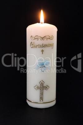 Lit white christening candle with blue detail