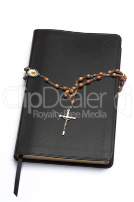 Rosary beads wrapped around the bible
