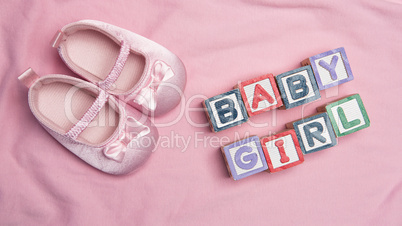Baby girl spelled out in blocks with pink booties