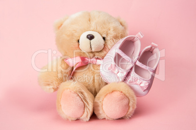 Fluffy teddy with pink ribbon and baby booties