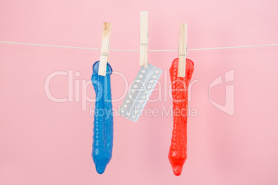 Contraceptive pill and condoms hanging from line