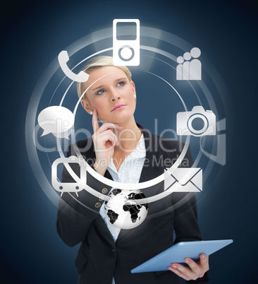 Thoughtful businesswoman with tablet pc considering various appl