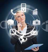 Thoughtful businesswoman with tablet pc considering various appl