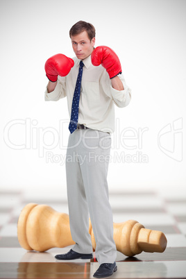 Businessman wearing boxing gloves on chessboard