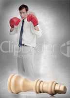 Businessman in boxing gloves with knocked over chess piece