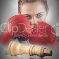 Powerful female boxer with knocked chess piece