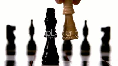 White king knocking over black king in chess
