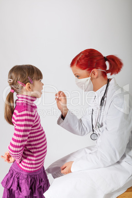 Die Kinderärztin schaut einem kleinen Mädchen in den Mund