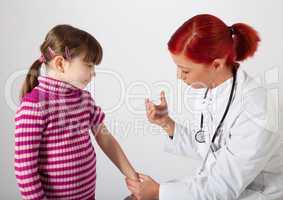 Die Kinderärztin impft ein kleinen Mädchen