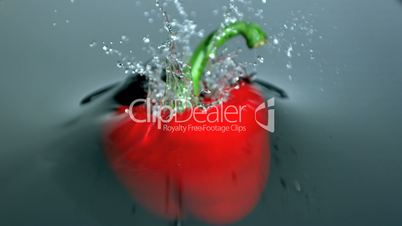 Red pepper falling into water