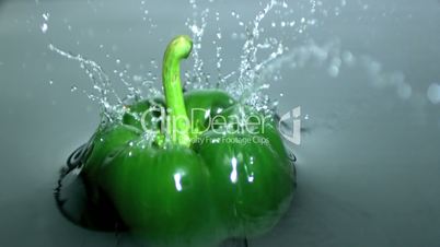 Green pepper falling into water