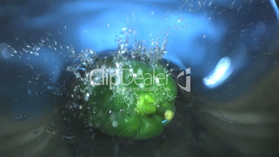 Green capsicum falling into water