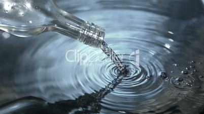 Water flowing into water from glass bottle