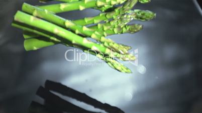Asparagus stalks falling into water