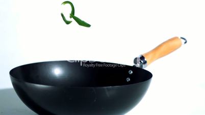 Sliced green pepper falling into wok