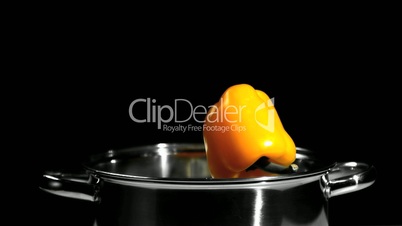 Yellow pepper falling into saucepan