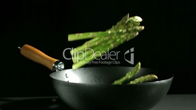 Asparagus falling into a wok