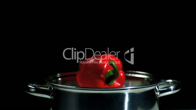 Red pepper falling into pot