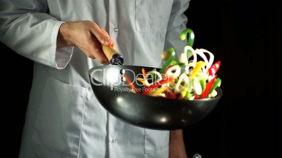 Chef tossing vegetable stir fry in wok