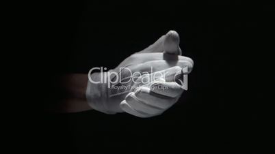 Gloved hands clapping on black background close up