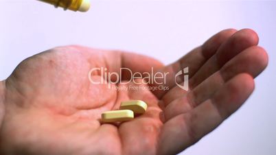 Tablets pouring into open palm