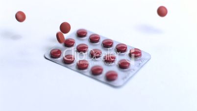 Red tablets crashing onto blister pack
