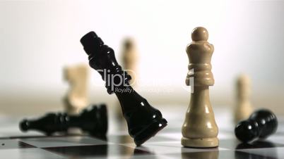 Black chess piece falling over