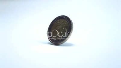Two euro coin revolving on white background