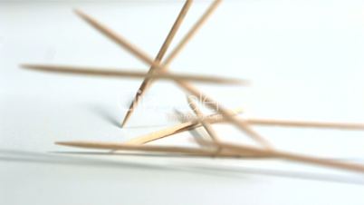 Toothpicks falling on white background