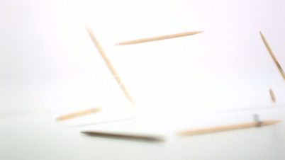 Cocktail sticks falling on white background