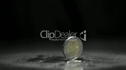 Two euro coin revolving on black background