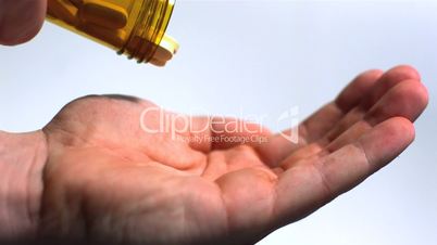 Large pills being poured into hand on white background