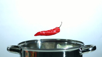 Red thai chili falling in a pot