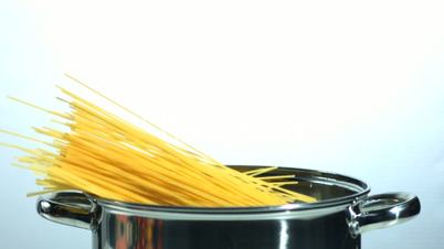 Spaghetti falling into a pot