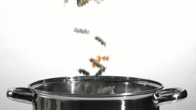 Fusilli falling into a saucepan in black and white