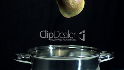 Turnip falling in pot on black background