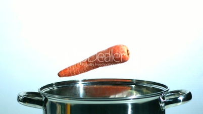 Three carrots falling in saucepan