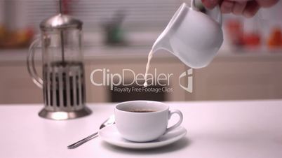 Milk pouring into coffee