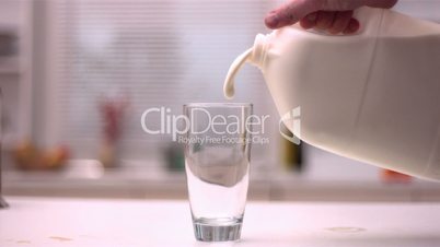 Milk being poured into glass in kitchen