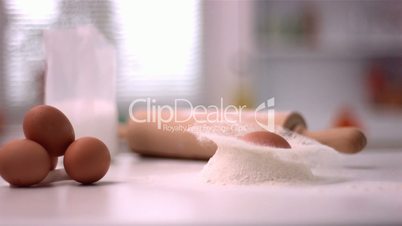 Egg falling in flour mound