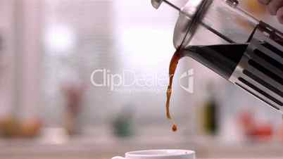 Cafetiere pouring coffee into cup