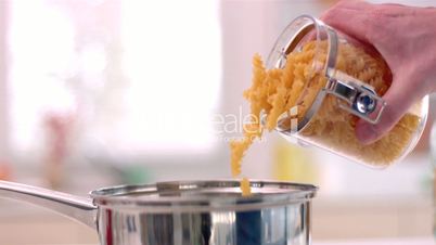 Fusilli pouring from jar to pot