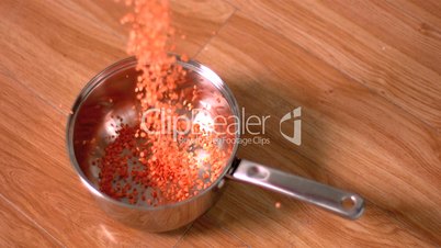 Red lentils pouring into pot