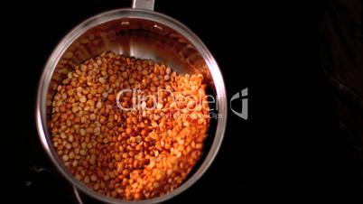 Popcorn shaking in pot on black background
