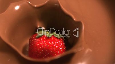 Strawberry falling into melted chocolate